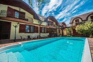 a swimming pool in front of a house at Marina Panzio in Siófok