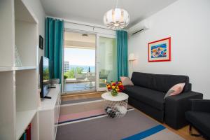 a living room with a couch and a tv at Apartment Morska vila in Split