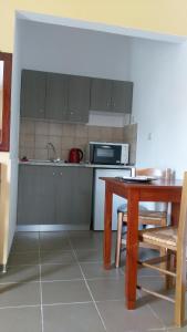 a kitchen with a table and a microwave at Zourpos Studios & Apartments in Kalyves