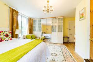 1 dormitorio con 1 cama grande y lámpara de araña en Molland Manor House Bed & Breakfast, en Sandwich