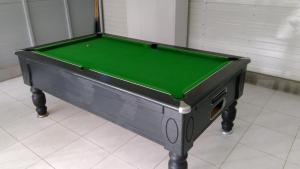 a pool table with a green top in a room at la cariole in Saint-Pierre