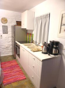 a kitchen with white cabinets and a counter top at Anastasia Luxury Villas in Gavrio