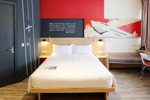 a bedroom with a large bed with a white bedsheet at Ibis Saigon Airport in Ho Chi Minh City