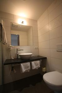 フシュル・アム・ゼーにあるHaus am Seeのバスルーム(洗面台、トイレ、鏡付)