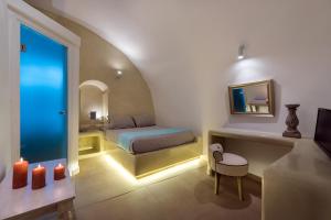 a bedroom with a bed and a mirror and candles at Nefeli Homes in Imerovigli