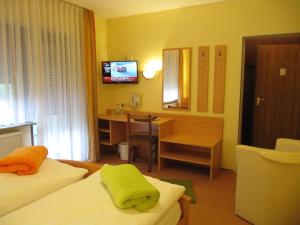 a hotel room with a bed and a desk at Hotel Gasthof am Selteltor in Wiesensteig