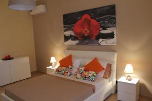 a bedroom with a bed with a red flower on the wall at Tortugas B&B in Giarre