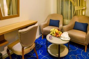 a room with chairs and a table with a bowl of fruit at سمايا الزهور للشقق المخدومة Samaya Alzohuor in Al Ahsa