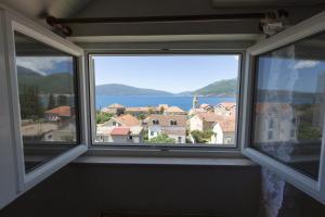 a window in a room with a view of the water at St. Roko Guest House in Tivat