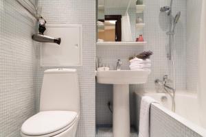 a bathroom with a white toilet and a sink at Lux Apartments Мытная 24 in Moscow