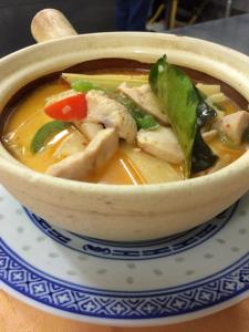 un bol de soupe de nouilles de poulet sur une assiette dans l'établissement Belle d'Asie, à Longué