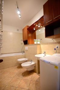 łazienka z 2 toaletami, umywalką i wanną w obiekcie Victus Apartamenty, Apartament Petit w mieście Sopot