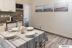 a dining room table with a blue and white striped table cloth at La Dimora sull'Arco in Monopoli