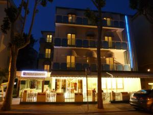 budynek w nocy z budynkiem z oświetleniem w obiekcie Hotel Gioiella w Rimini
