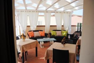 un soggiorno con 2 tavoli e un divano di B&B Kenzia a Olbia
