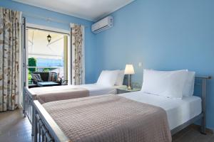 2 łóżka w pokoju z balkonem w obiekcie Diamante Beachfront Suites w mieście Xylokastron