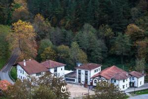 a group of white houses with a road and trees at Casa Rural Eleizondo Haundia in Itziar