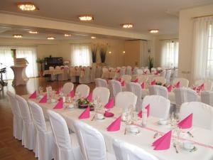 une salle de banquet avec des tables blanches et des serviettes roses dans l'établissement Hotel Gasthof am Selteltor, à Wiesensteig