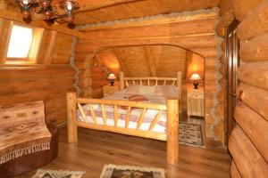 1 dormitorio con 1 cama en una cabaña de madera en Vadul Lupilor, en Moisei