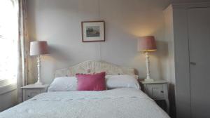 a bedroom with a bed with a pink pillow on it at The Merlin in Marlborough