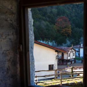 a woman is looking out of a window at a church at Casa Rural Eleizondo Haundia in Itziar