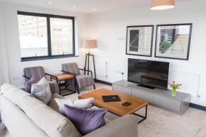 a living room with a couch and a tv at City Aldgate Apartments in London