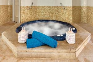 a room with a hot tub with a pair of shoes at Cala Millor Garden Hotel - Adults Only in Cala Millor