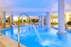 a swimming pool with water slides in a hotel at Cala Millor Garden Hotel - Adults Only in Cala Millor