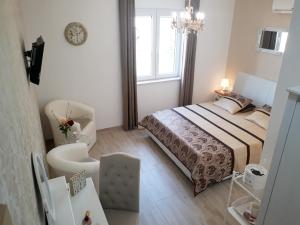 a bedroom with a bed and a chair and a window at Apartments Jo in Senj