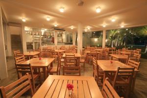 an empty restaurant with wooden tables and chairs at Arugambay Roccos in Arugam Bay