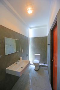 a bathroom with a sink and a toilet at Arugambay Roccos in Arugam Bay