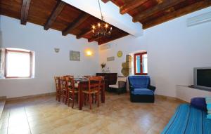 a dining room and living room with a table and chairs at Holiday House Ivana in Dobropoljana