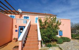 a staircase leading to a pink house with blue doors at Holiday House Ivana in Dobropoljana