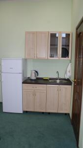 a kitchen with a sink, stove, and cabinets at Hotel Olimp in Vyalki
