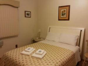 1 dormitorio con 1 cama con 2 toallas en ap 101, en Gramado