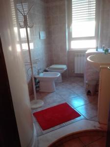 フィウミチーノにあるB&B melodyのバスルーム(トイレ、シンク、赤い敷物付)