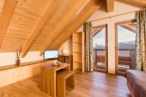 a living room with wooden ceilings and large windows at UALM Untermarkter Alm in Imst