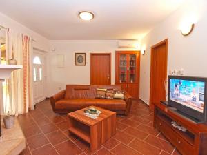 een woonkamer met een bank en een tv bij House Franko 1330 in Poreč