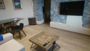 - un salon avec une télévision et une table dans l'établissement Apartments Opatija-Ičići, à Ičići
