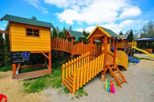 a group of wooden play structures in a playground at Willa Kamilówka in Rabka-Zdrój