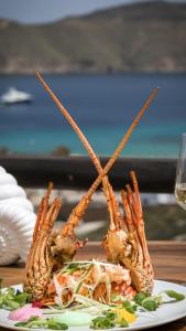 a plate of food with three lobsters on a table at Mykonos Panormos Villas in Mykonos
