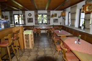 a restaurant with tables and chairs and a bar at Pension Zum Grünen Wald in Feuchtwangen