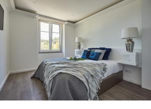 una camera da letto con un letto con cuscini blu e una finestra di Sintra Design Apartment a Sintra