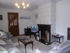 Una sala de estar con chimenea y televisión. en Quay West Ireland, en Westport