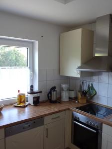a kitchen with white cabinets and a wooden counter top at Strandleben 4 in Grömitz