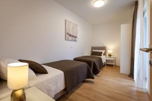 a bedroom with two beds and a table with a lamp at Sunny Garden Lux in Split +41 photos