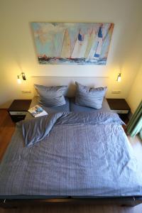 a bedroom with a large bed with a painting on the wall at Villa Harmonie W1 in Göhren-Lebbin