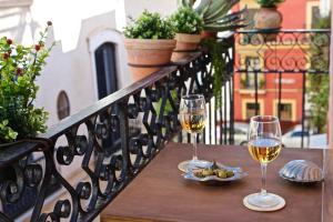 two glasses of wine on a table on a balcony at Eva Recommends Sentencia in Seville