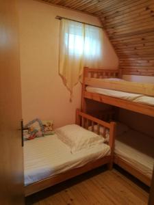 ein Zimmer mit einem Etagenbett, 2 Etagenbetten und einem Fenster in der Unterkunft Family House Rostovo in Čardaci