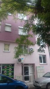 a pink building with a car parked in front of it at Studio Ulpia in Plovdiv